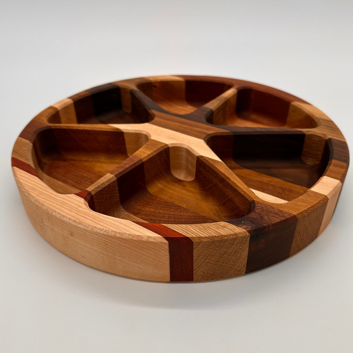 Wooden cutting board with segmented design on a white background