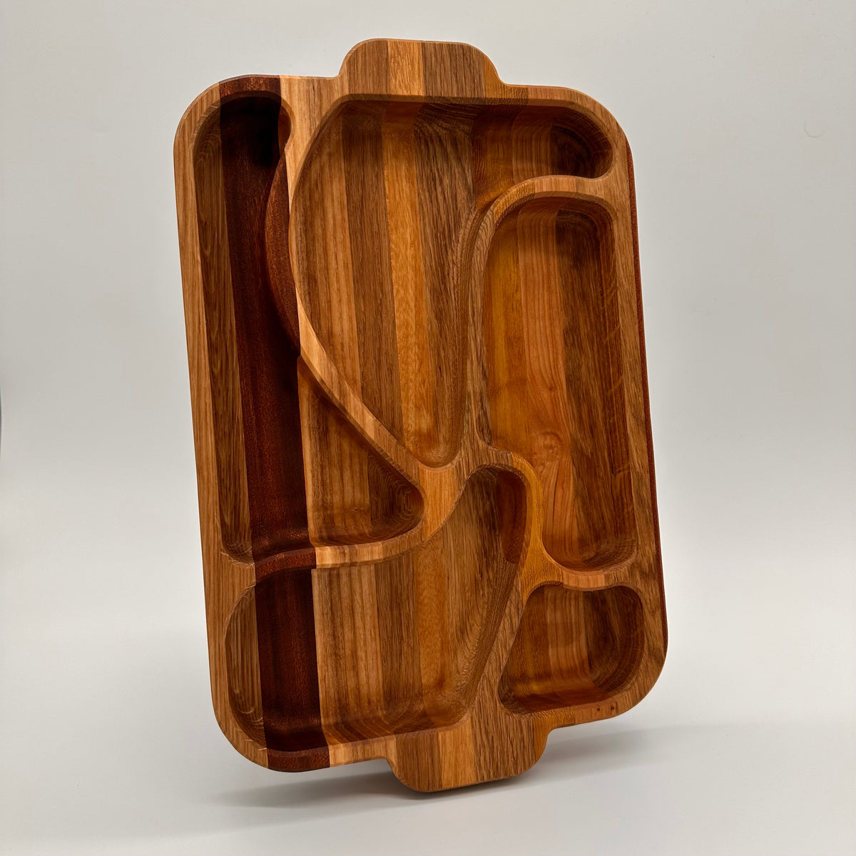 Wooden tray with geometric compartments on a light gray background