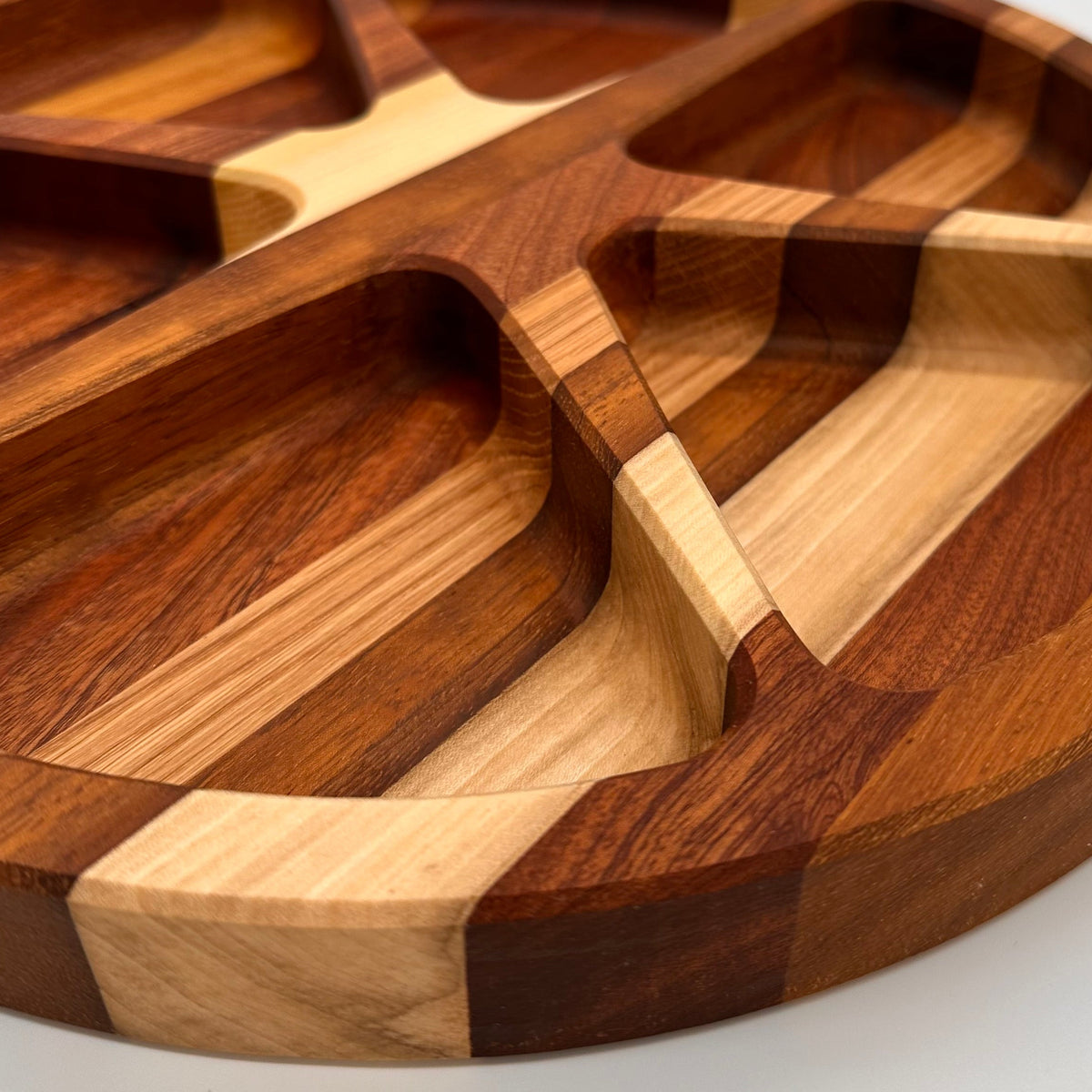 Wooden cutting board with segmented design on a white background
