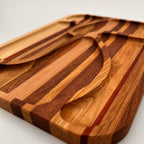 Wooden cutting board with a spoon and fork cutouts on a white background