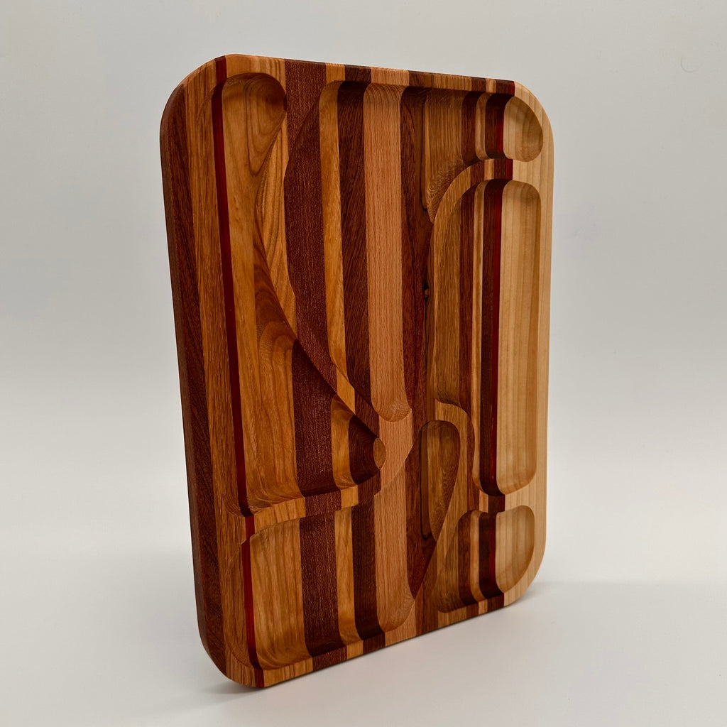 Wooden cutting board with embedded knife and fork on a light gray background