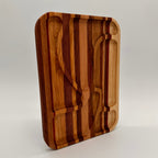 Wooden cutting board with embedded knife and fork on a light gray background