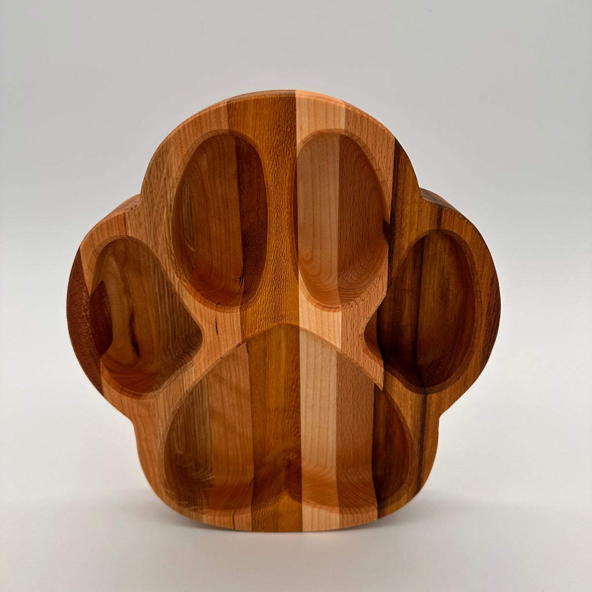 Wooden paw-shaped bowl on a light gray background