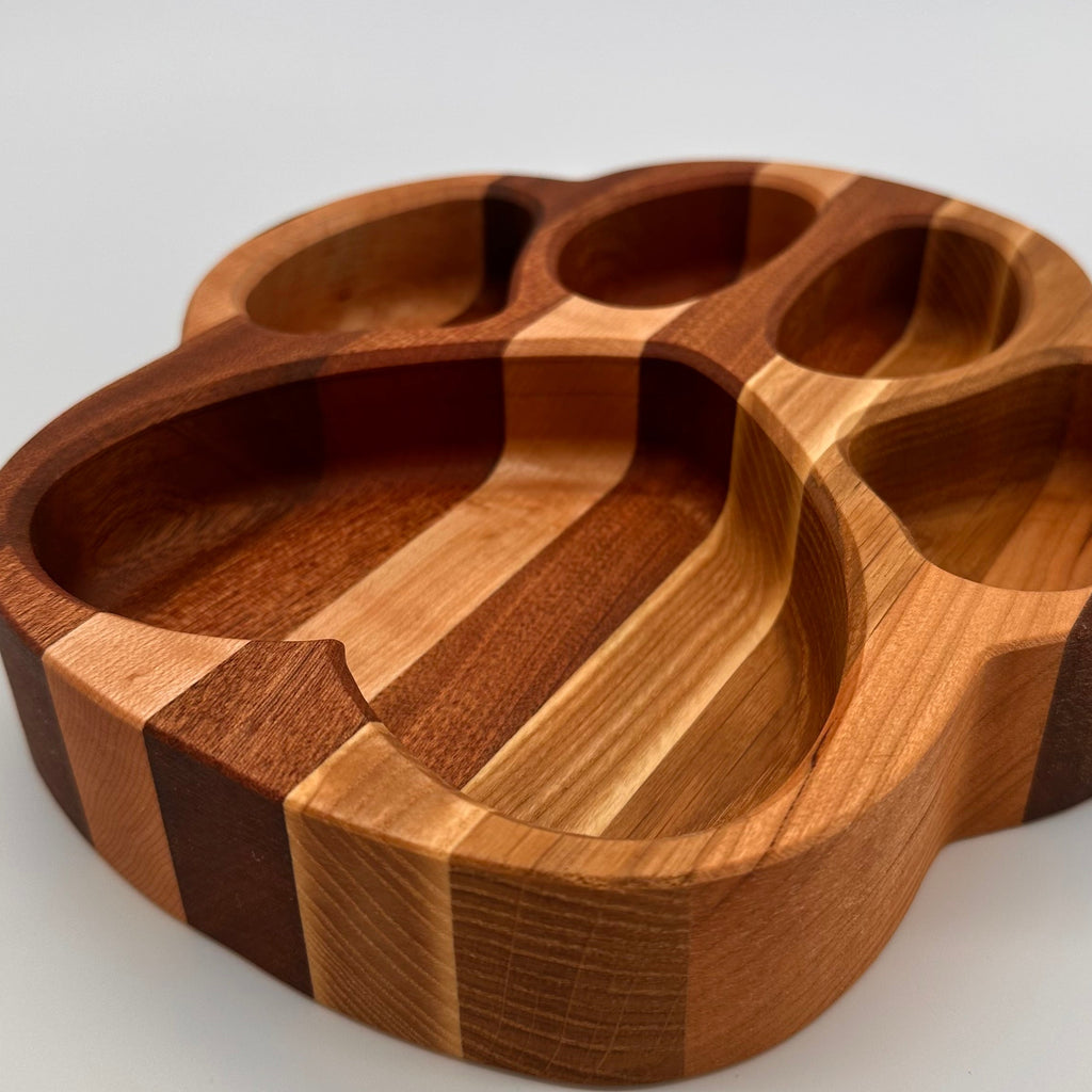 Wooden paw-shaped tray on a light gray background