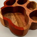 Wooden paw-shaped holder with multiple compartments on a light background