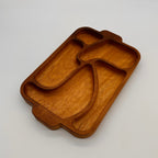 Wooden tray with divided sections on a light gray background