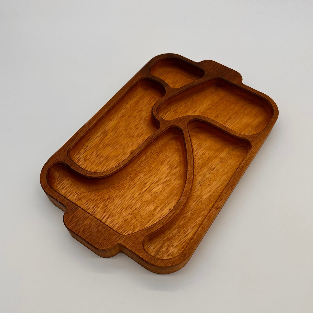Wooden tray with divided sections on a light gray background