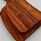 Wooden cutting board with handles on a light gray background