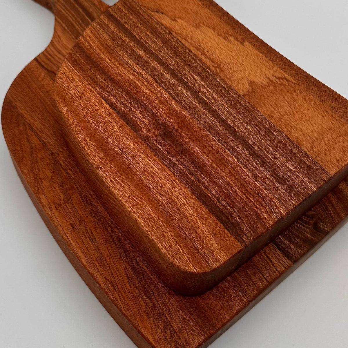 Wooden cutting board with handles on a light gray background