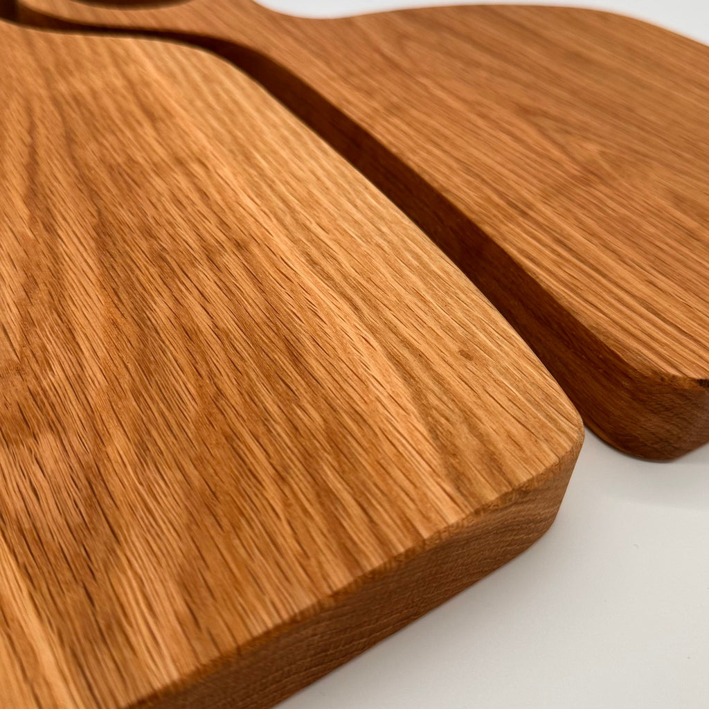 Two wooden cutting boards with handles on a white background