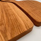Two wooden cutting boards with handles on a white background