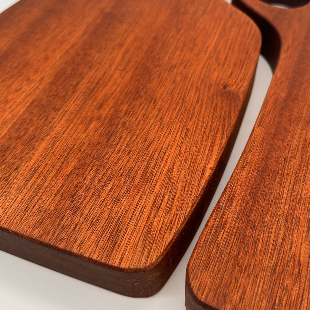 Two wooden cutting boards with handles on a white background