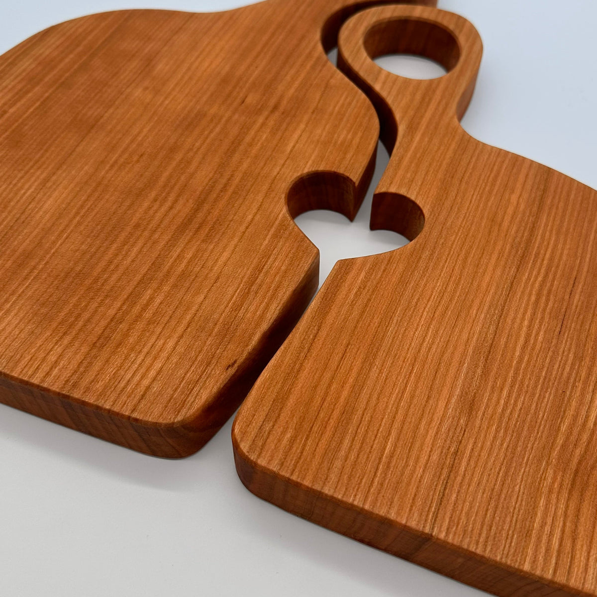 Two wooden serving boards with handles on a light gray background