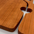 Wooden cutting board with handles on a light gray background