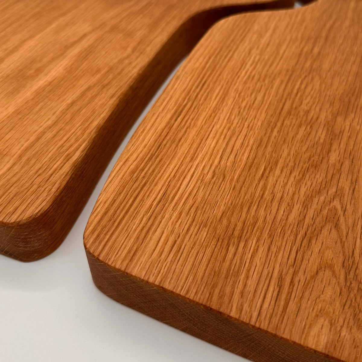 Two wooden cutting boards with handles on a white background