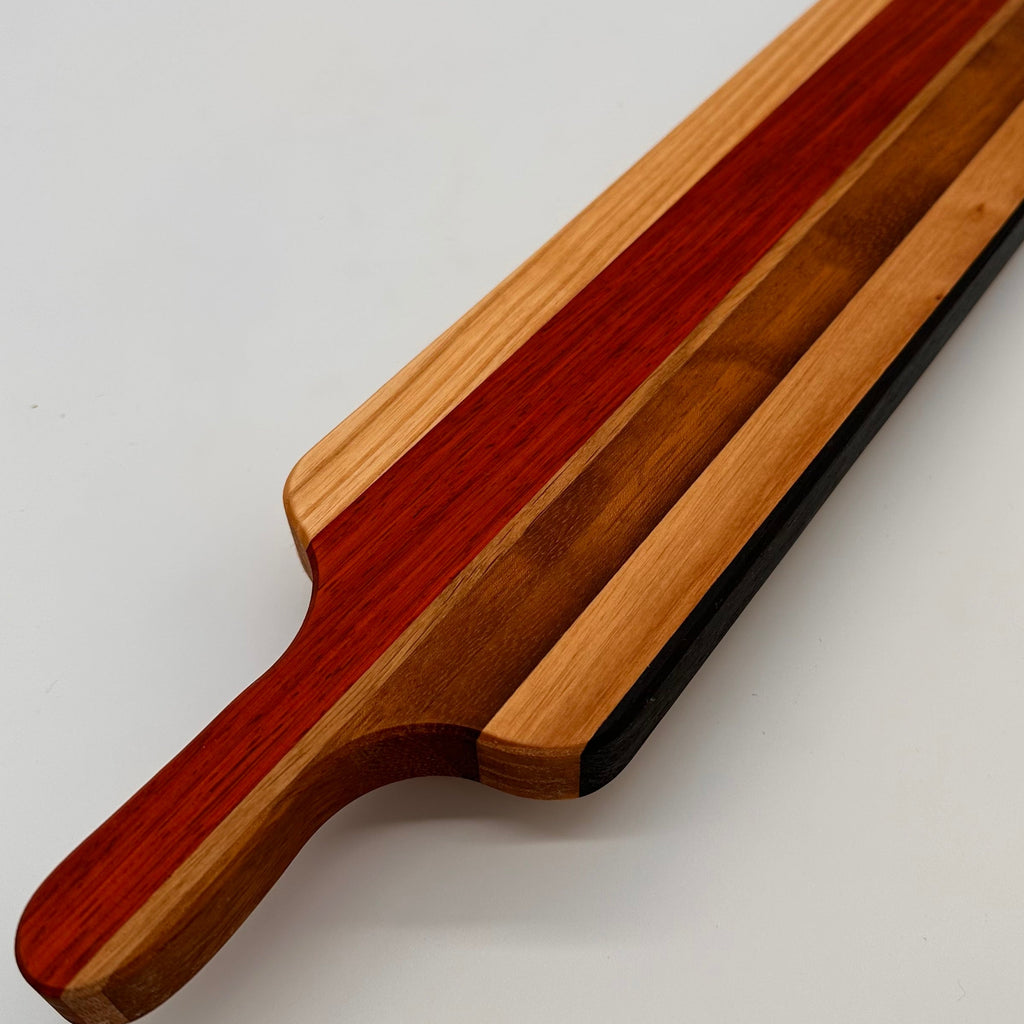 Wooden cutting board with a handle on a light gray background