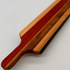 Wooden cutting board with a handle on a light gray background