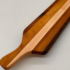Wooden paddle with a striped design on a light gray background
