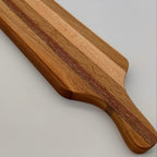 Wooden cutting board with a handle on a light gray background