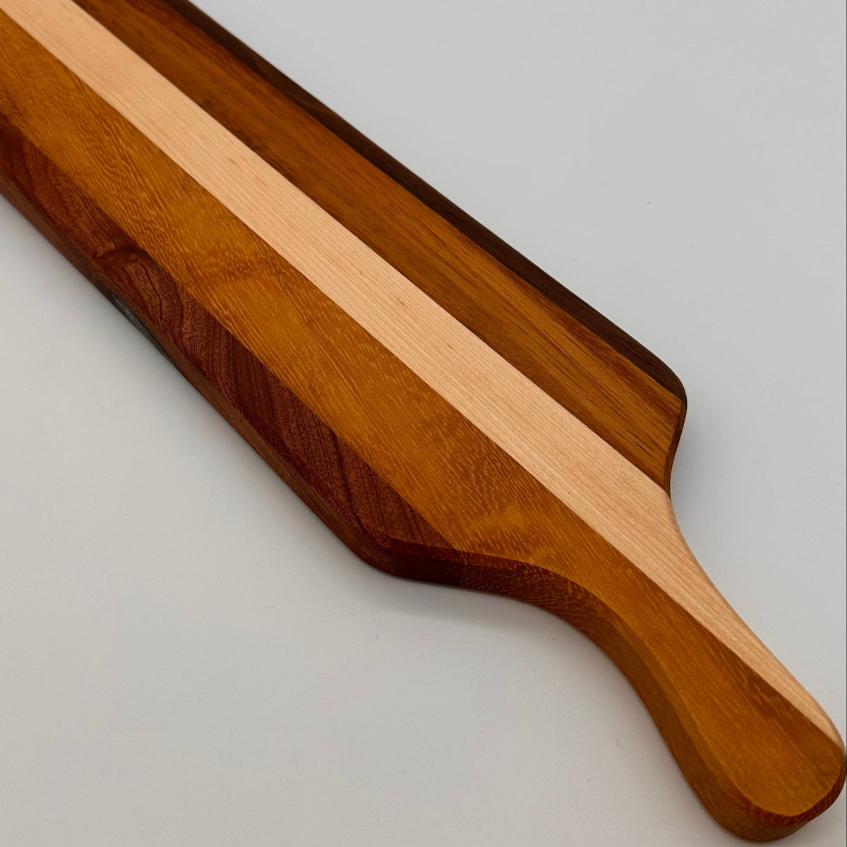 Wooden cutting board with a striped design on a gray background