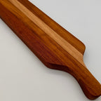 Wooden cutting board with a handle on a light gray background