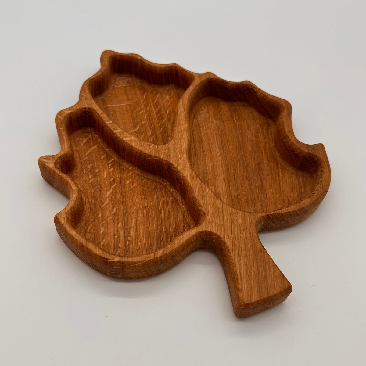Wooden leaf-shaped tray on a light gray background