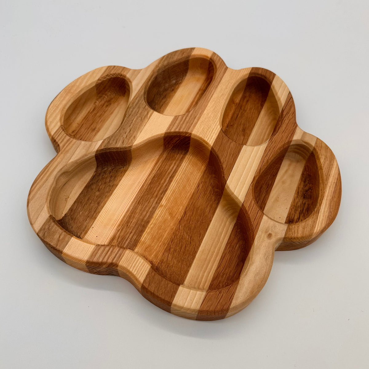 Wooden paw-shaped tray on a light gray background