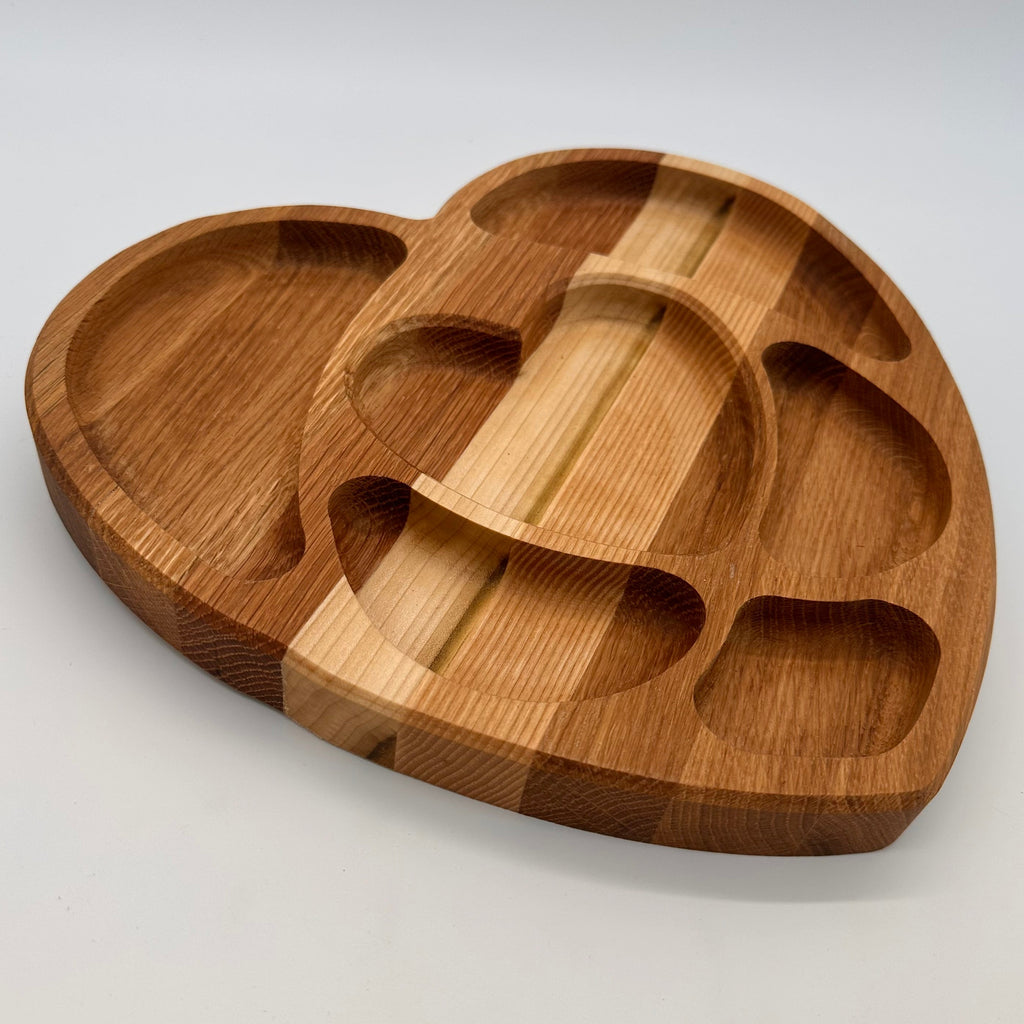 Wooden tray with heart-shaped compartments on a white background