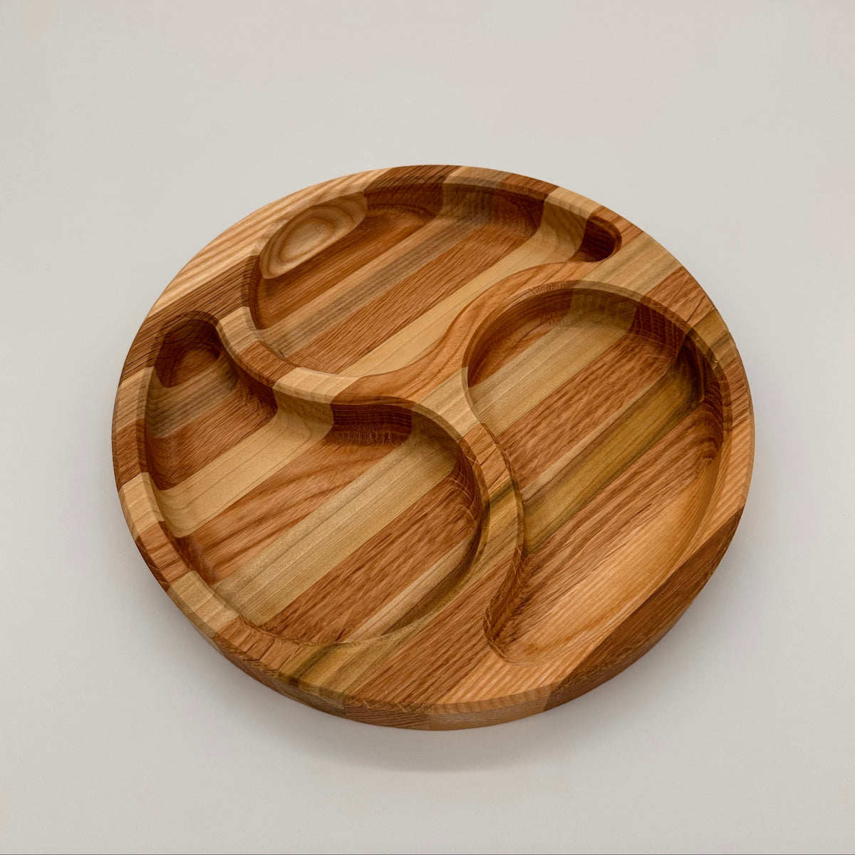 Wooden tray with divided sections on a light gray background