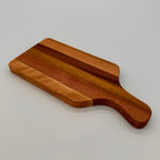 Wooden cutting board with a handle on a light gray background