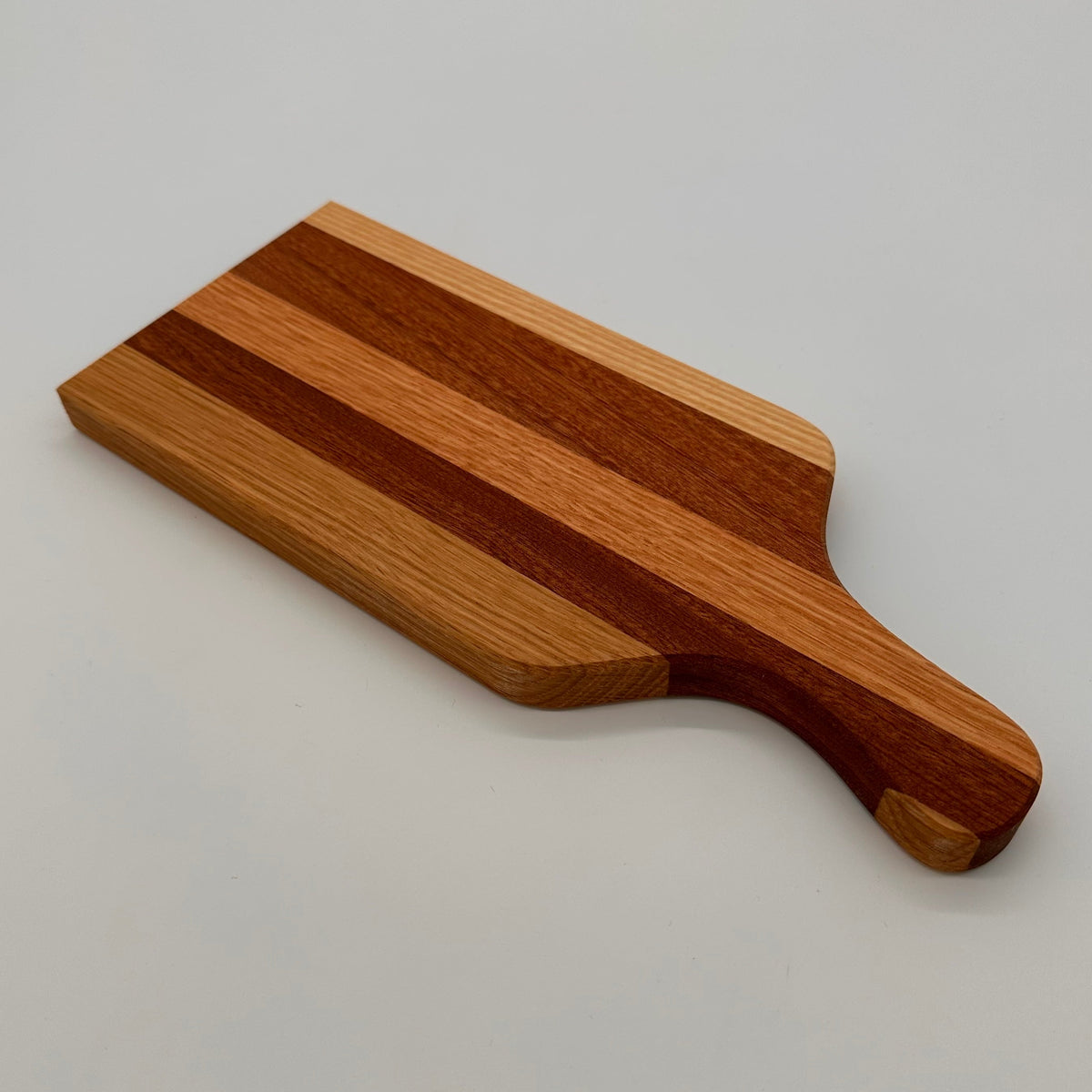 Wooden cutting board with a handle on a light gray background