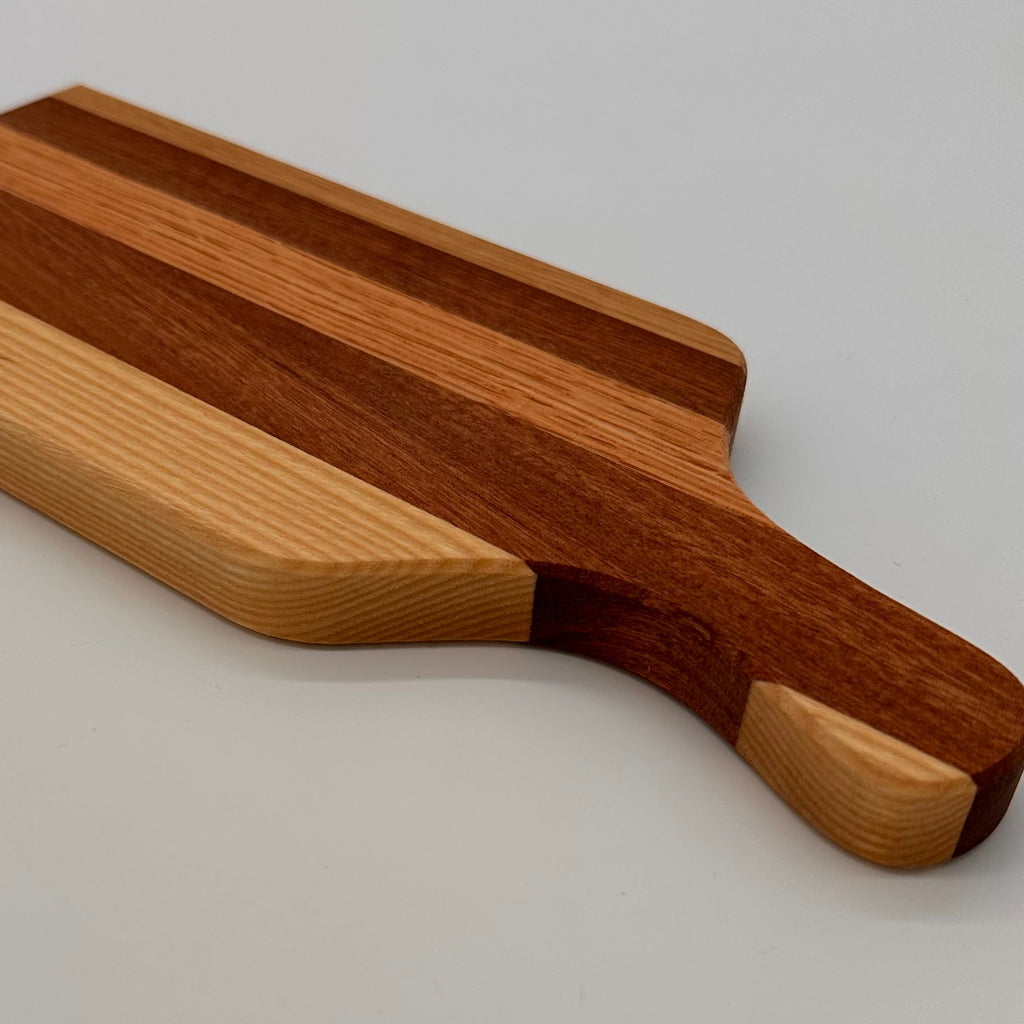 Wooden cutting board with a handle on a light gray background