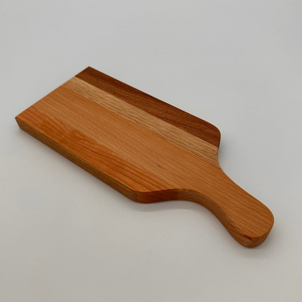 Wooden paddle with a handle on a light gray background