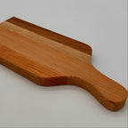 Wooden paddle with a handle on a light gray background
