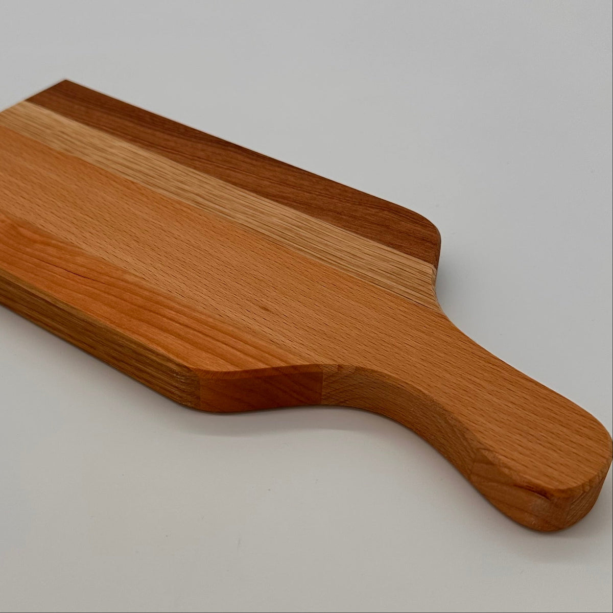 Wooden paddle with a handle on a light gray background