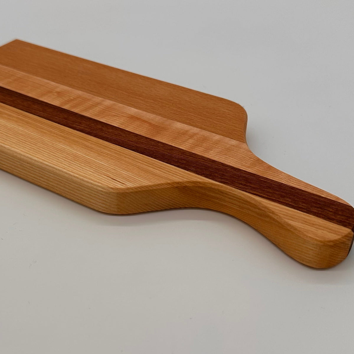 Wooden cutting board with a dark stripe on a light gray background