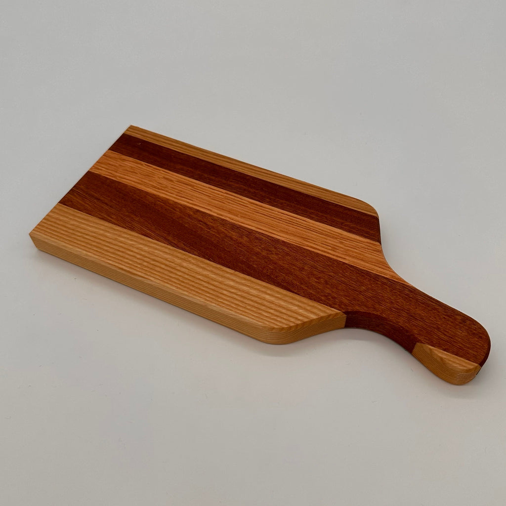 Wooden cutting board with a handle on a light gray background
