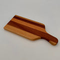 Wooden cutting board with a handle on a light gray background