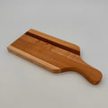Wooden cutting board with a handle on a gray background