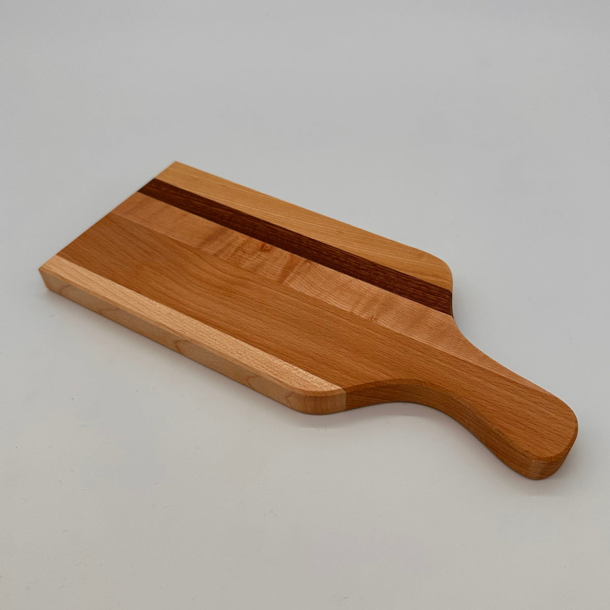 Wooden cutting board with a handle on a gray background
