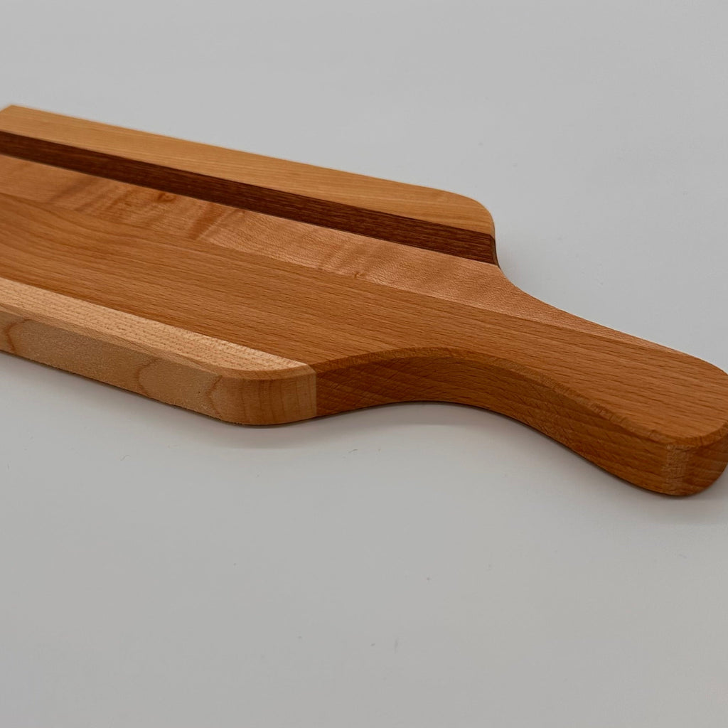 Wooden cutting board with a handle on a gray background