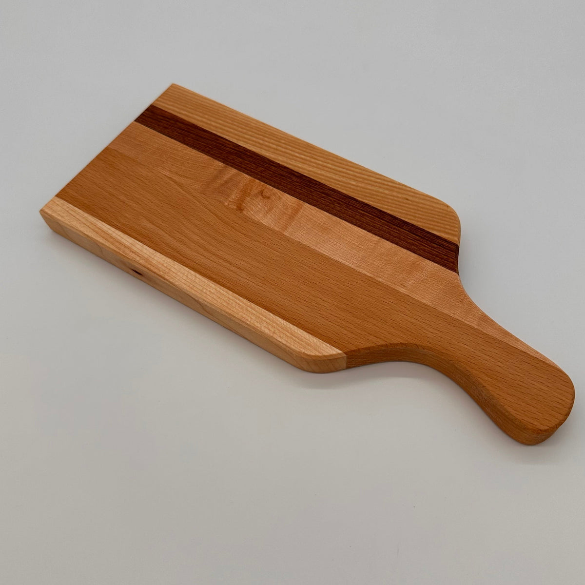 Wooden cutting board with a dark stripe on a light gray background