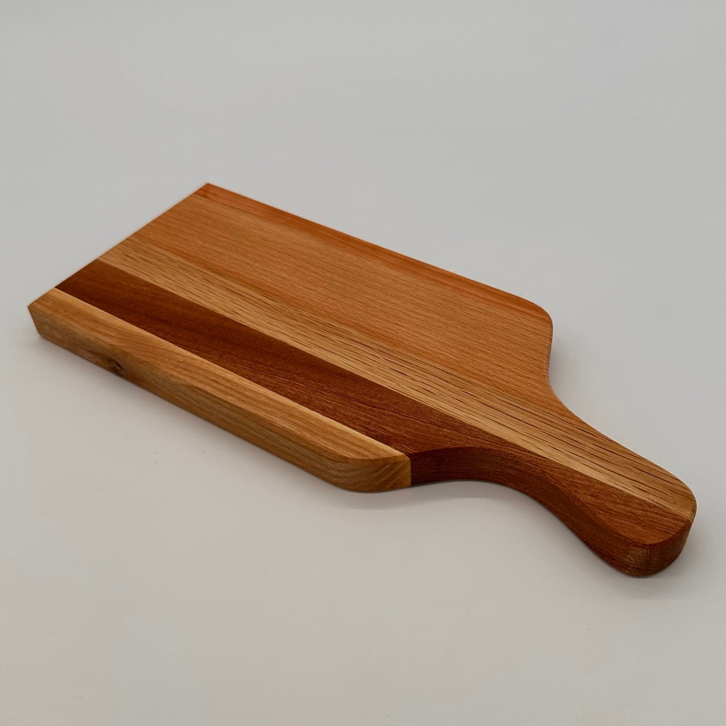 Wooden cutting board with handle on a light gray background