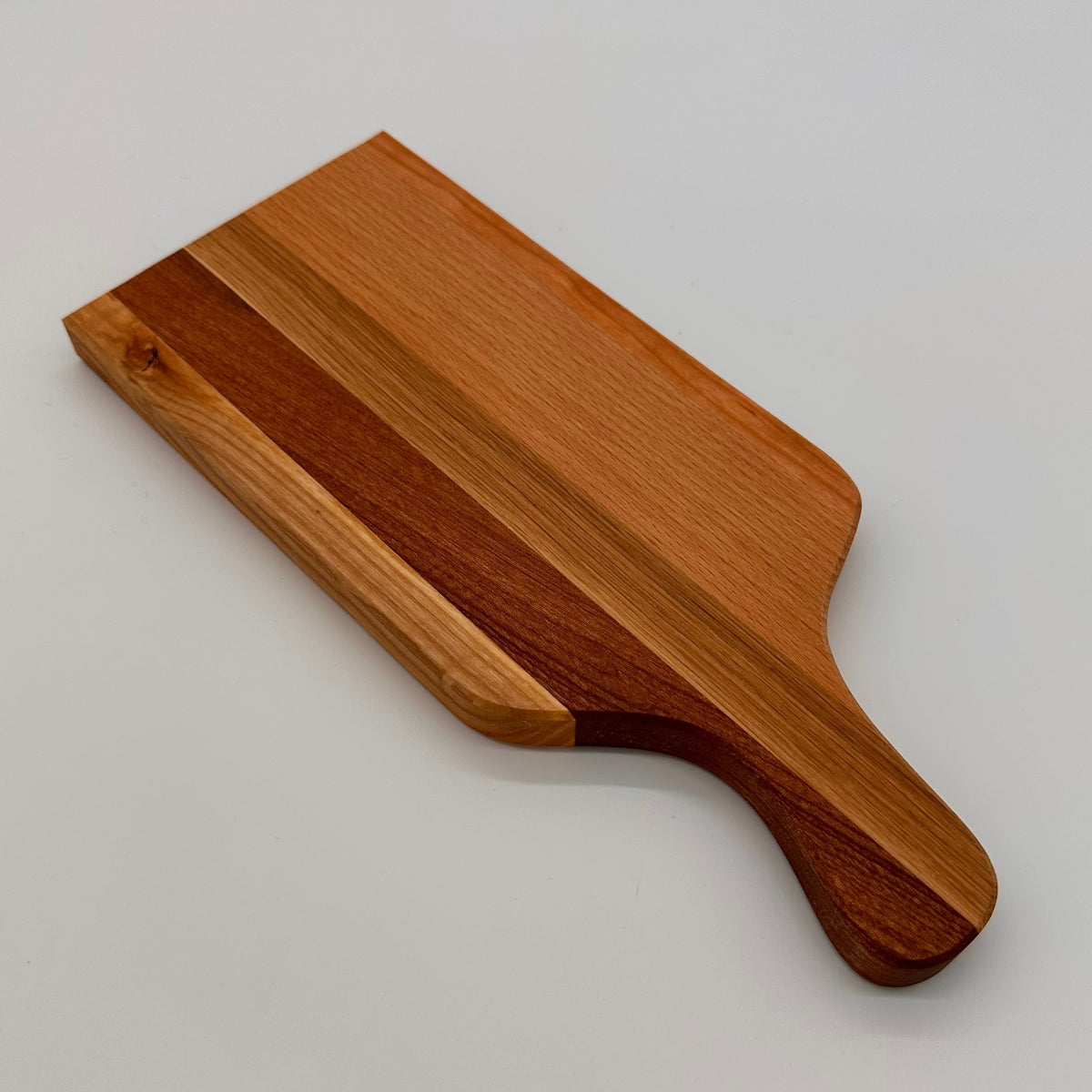 Wooden cutting board with a handle on a light gray background
