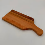 Wooden cutting board with handle on a light gray background