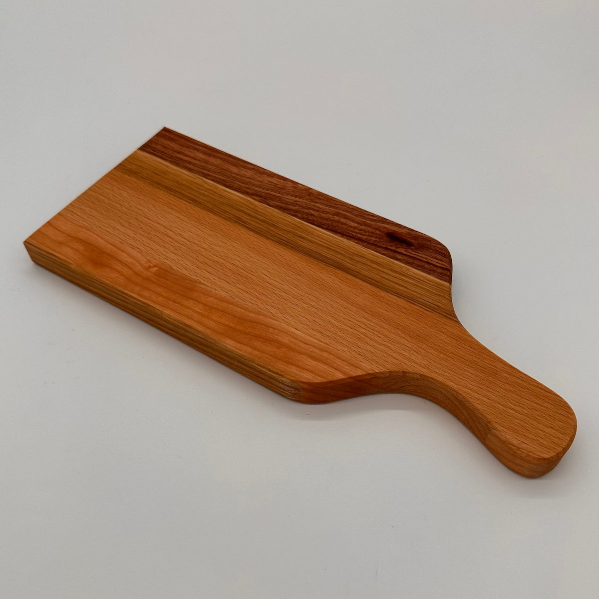 Wooden cutting board with handle on a light gray background