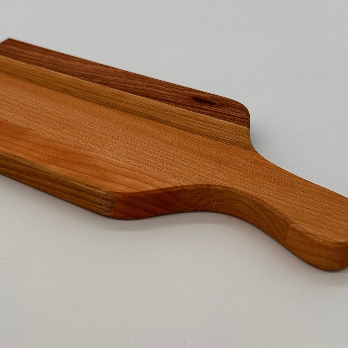 Wooden cutting board with handle on a light gray background