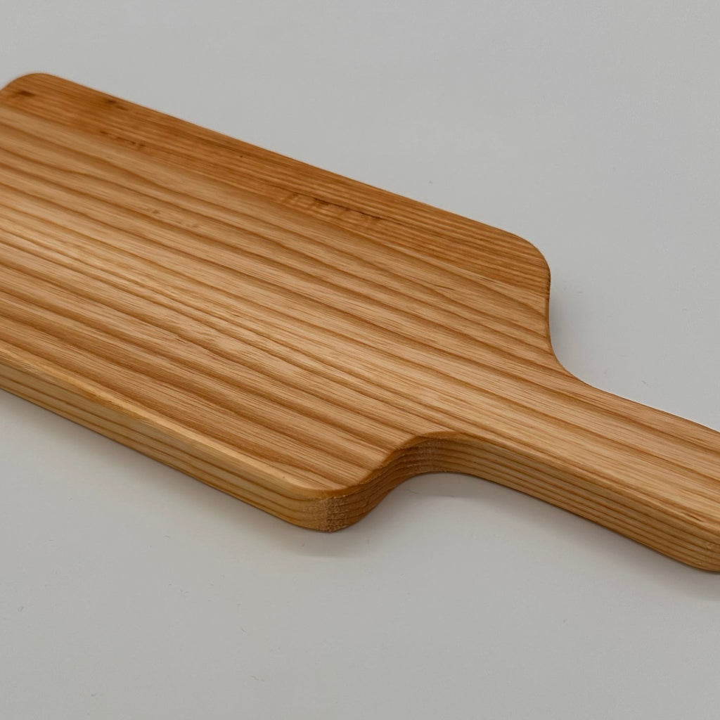 Wooden paddle with a handle on a light gray background