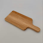 Wooden paddle cutting board on a light gray background