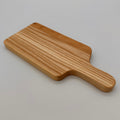 Wooden paddle cutting board on a light gray background